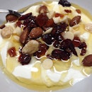 Greek yogurt topped with trail mix and an overabundant drizzle of honey..