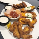 Wagon Wheel Sampler Platter: potato skins, crisp fried zucchini, shrimp cocktail and chicken strips for $22.90, served up with various dipping sauces.