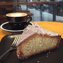 A slice of lemon cake and a cappuccino.