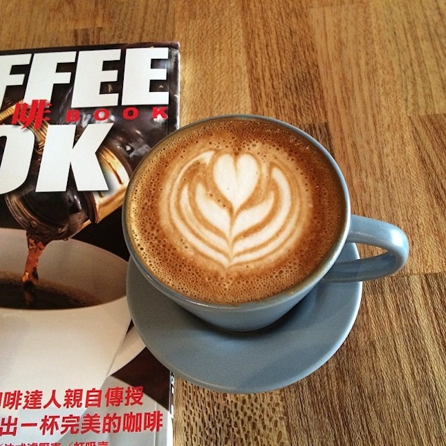 sipping a Flat White while reading a coffee book