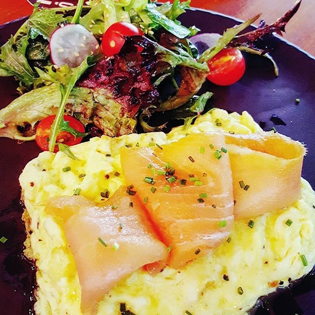 🍳: Luscious ribbons of smoked salmon draped on a bed of scrambled eggs.