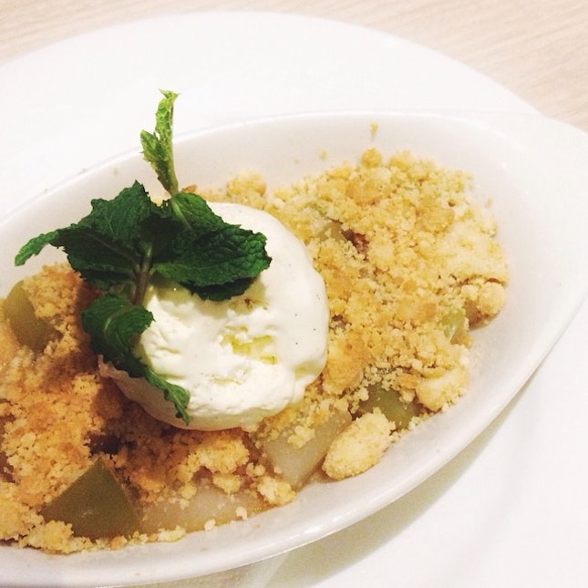 Apple and pear crumble served with a scoop of vanilla bean ice cream.