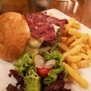 Having a juicy beef burger with beef bacon at Two Sons Bistro.