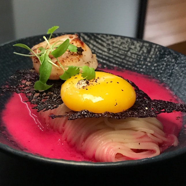 Sautéed scallop on Japanese somen noodles with 64-degree Celsius sous vide egg yolk in bonito-kombu broth topped with violet tuille • S$18++