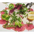 Carpaccio Di Manzo - raw thin slices of beef tenderloin in a dressing of olive oil and lemon juice, topped with fresh Parmesan cheese and arugula.