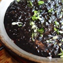 Arroz Negro: Paella of Squid Ink, Squid, Dry Sherry, Fish Stock, Spring Onions & Black Mushrooms.