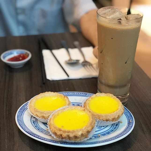 Life’s simple pleasures - flakey hot egg tarts and iced milk tea from @honolulucafesg.
