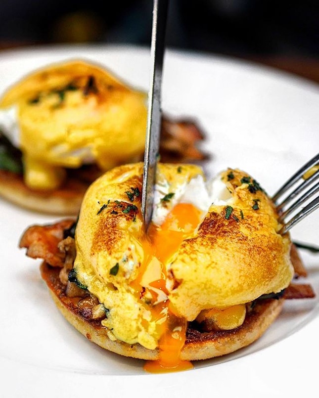 [Ash & Elm] - Poached Eggs doused in a creamy hollandaise sauce atop bacon, spinach and English muffin.