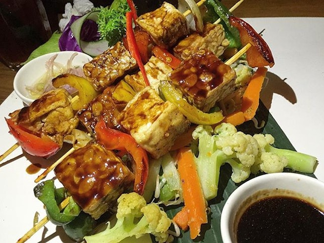 Grilled tofu and tempeh with kicap manis on skewers over a bed of baked vegetables...slaying it like a true vegan.
